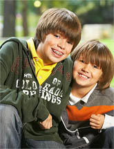 photo of two smiling boys, one is wearing braces